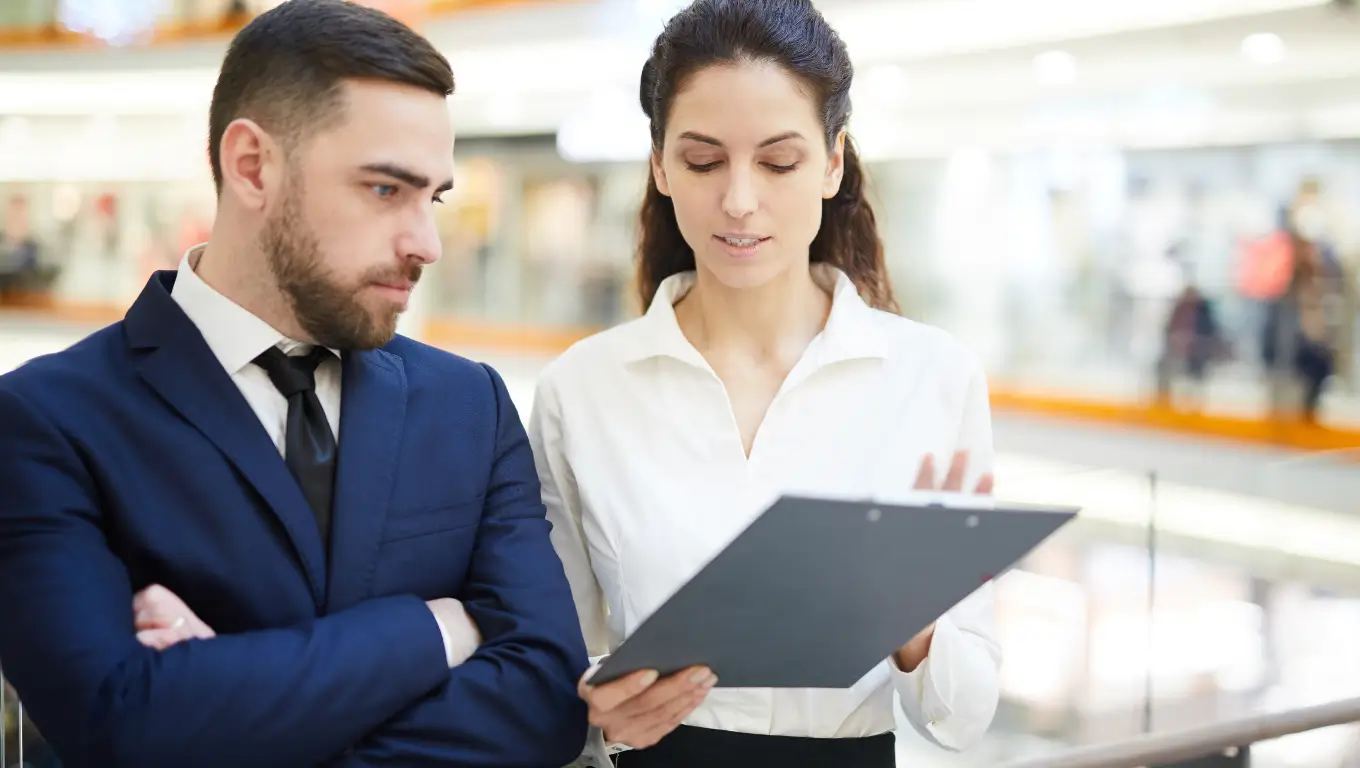 Mulher explicando para homem de negócios como funciona a fiança empresarial